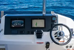 Helm of 2025 Leopard 40 Powercat with navigation screens and steering wheel, ocean background.