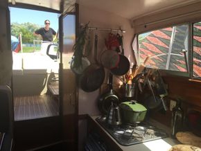 Interior of cabin, kitchen and stove, looking out from v-berth