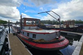 1926 Dutch Barge Luxemotor moored at a marina under a partly cloudy sky.