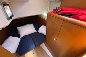 Cozy cabin interior of 2020 Jeanneau Sun Odyssey 389 sailboat with pillows and storage.