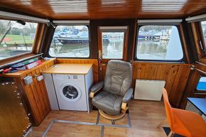 Interior of a 1921 Classic Dutch Barge with wooden paneling and modern amenities.