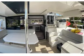 Spacious interior of a 2022 Leopard 45 catamaran with modern seating and dining area.