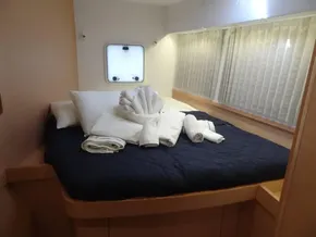 Lagoon 42 2020 model bedroom with neatly arranged bed and towels.