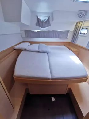 2020 Lagoon 42 yacht interior cabin with bed, pillows, and natural light.