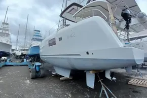2024 Lagoon 42 catamaran in a boatyard, surrounded by other vessels.