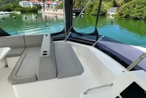2022 Leopard 53 Powercat interior with seating, overlooking serene waterfront and lush greenery.