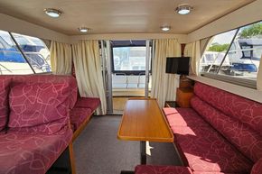 Interior of 1989 Princess 35 Flybridge yacht with red seating and wooden table.
