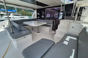 Spacious deck area of a 2021 Leopard 45 catamaran with seating and table.