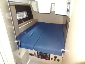 Interior cabin of 2020 Beneteau Oceanis 46.1 with blue bedding and control panels.