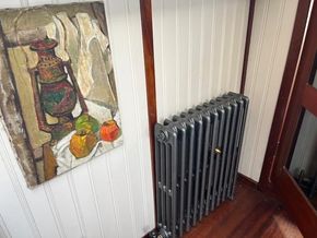 Painting and radiator inside a 1901 Classic Dutch Barge with wood paneling.