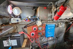 Electrical setup inside a 1927 Classic Dutch Barge, featuring wiring, battery, and equipment.