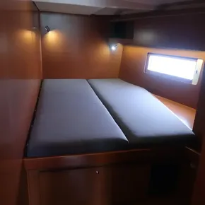 Cozy cabin interior of 2018 Beneteau Oceanis 51.1 yacht with bed and window.
