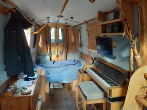 Large double bed set up in the bow with piano saloon