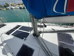 Jeanneau Sun Odyssey 440 sailboat deck with solar panels, docked in a marina.