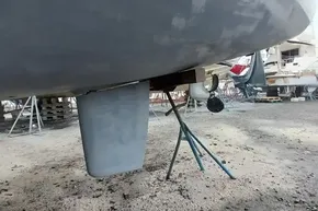 2024 Lagoon 42 catamaran under maintenance, showing hull and rudder details.