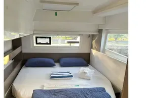 Luxurious cabin interior of 2022 Leopard 42 yacht with cozy bedding and natural light.
