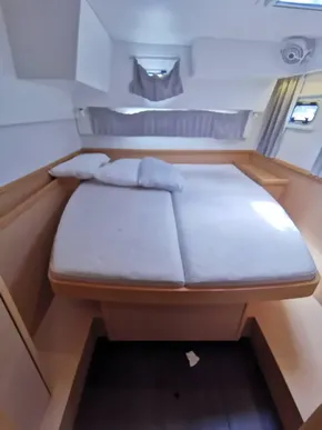 2020 Lagoon 42 yacht interior cabin with bed, pillows, and natural light.
