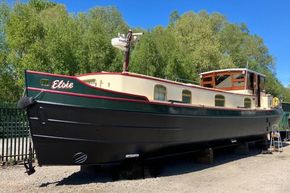 Replica Dutch Barge 57 by Delta Marine, 2005, docked with lush greenery background.