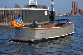 2026 Enkhuizensloep 680 Tender boat cruising near a dock with a colorful flag.