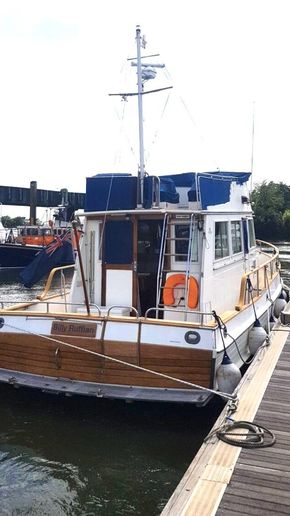 1991 Grand Banks 36 Sedan docked at marina, rear view.