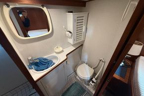Compact bathroom in a 1994 Linssen 360 AC yacht, featuring sink, mirror, and toilet.