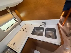 2019 Jeanneau Sun Odyssey 440 galley with dual sinks and wooden cabinetry.