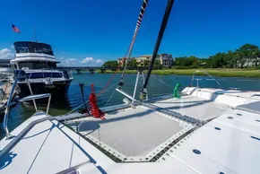 Catamaran deck view with ropes, docked near a yacht, clear blue sky, Leopard 50, 2022 model.