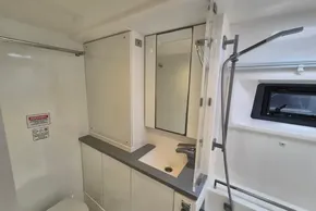 Modern bathroom in 2021 Leopard 45 yacht with shower, sink, and window.