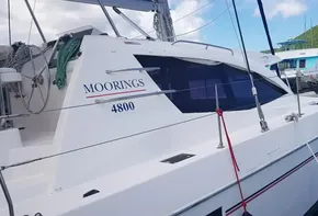 2017 Leopard 48 catamaran Moorings 4800 docked at marina with green hills in background.