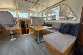 Interior of 2024 Piper 12c boat with seating area and large windows.