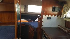 1982 Fairline Mirage 29 Aft Cabin interior with wood finish and cozy sleeping area.