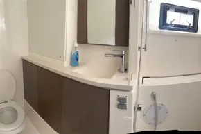 Modern bathroom in 2022 Leopard 45 yacht with sink, toilet, and window.
