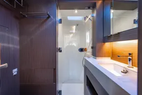 Modern bathroom in 2025 Leopard 46 yacht with sleek wood paneling and glass shower.