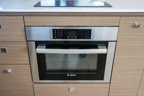 Modern Bosch oven in sleek wooden kitchen cabinetry, Leopard 46 model, 2025.