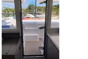 Interior view of 2022 Leopard 45 catamaran, showcasing door to deck and scenic marina.