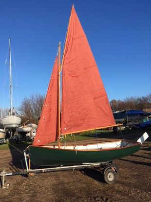 Gunter-rigged wooden sailing dinghy