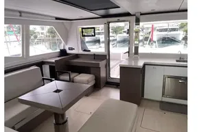 Luxurious interior of 2022 Leopard 45 catamaran with modern seating and kitchen area.
