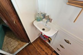 Small vintage sink area on a 1927 Classic Dutch Barge with wooden flooring.