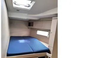 Interior cabin of 2023 Beneteau Oceanis 51.1 yacht with blue bedding.