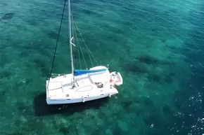 Aerial view of 2008 Leopard 38 catamaran sailing on clear turquoise waters.
