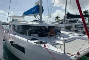 2020 Leopard 45 catamaran docked at marina with two people on deck.