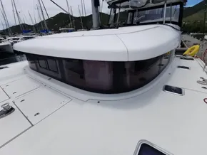 2020 Lagoon 42 catamaran, sleek design, docked in marina with scenic mountain backdrop.