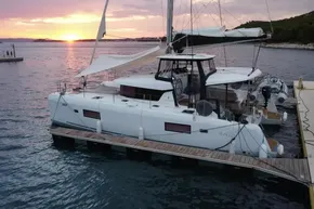 2024 Lagoon 42 catamaran docked at sunset, featuring sleek design and modern amenities.