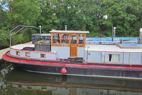 Vintage 1926 Dutch Barge Luxemotor moored by lush greenery, with 