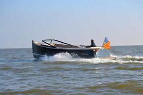 2026 Enkhuizensloep 744 Tender cruising on open water with a colorful flag.
