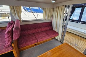 Interior of 1989 Princess 35 Flybridge yacht with red seating and wooden flooring.