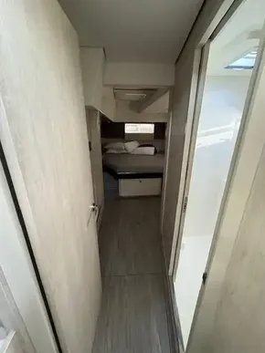 Narrow hallway in 2020 Leopard 50 yacht leading to cozy bedroom.