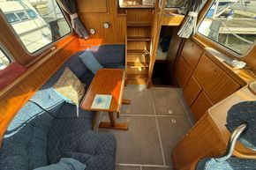 Cozy interior of 1994 Linssen 360 AC yacht with wooden furnishings and seating area.
