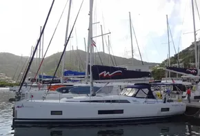 Beneteau Oceanis 46.1 2020 sailboat docked in a marina with scenic mountain backdrop.