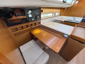 Interior of 2019 Jeanneau Sun Odyssey 440 yacht, featuring navigation station and modern kitchen.